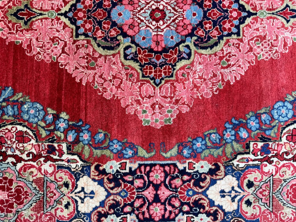 Hand-knotted antique Persian Sarouk wool rug featuring a large central floral medallion on a rich red ground with elaborate decorative borders. View XIII