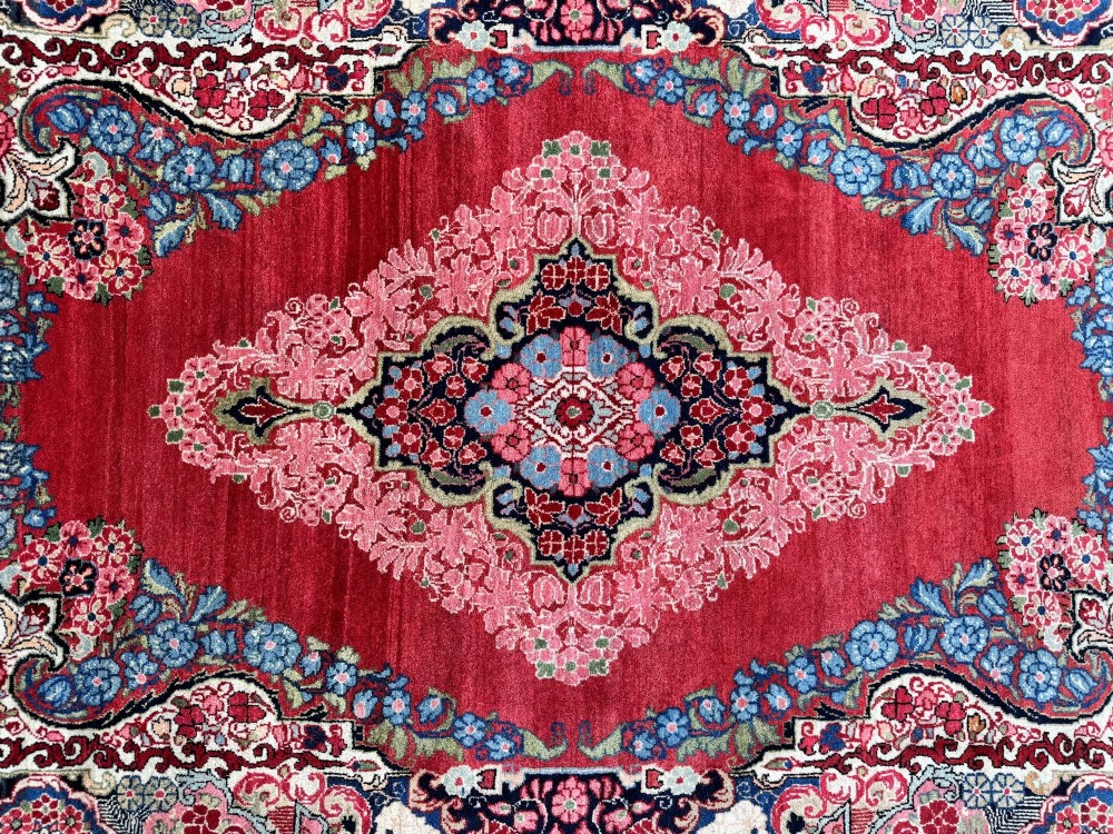 Hand-knotted antique Persian Sarouk wool rug featuring a large central floral medallion on a rich red ground with elaborate decorative borders. View XIV