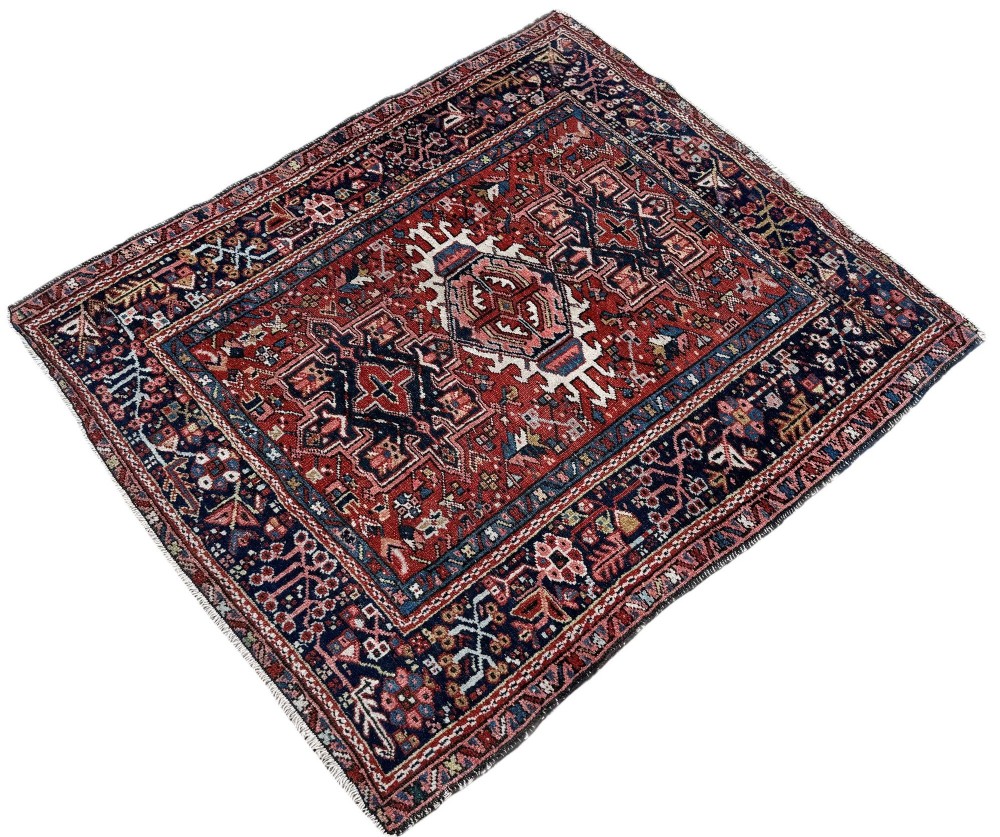 An antique hand-knotted Karaja rug featuring three geometric central medallions in pink, blue, and navy on a crimson red field surrounded by a dark navy border. View III