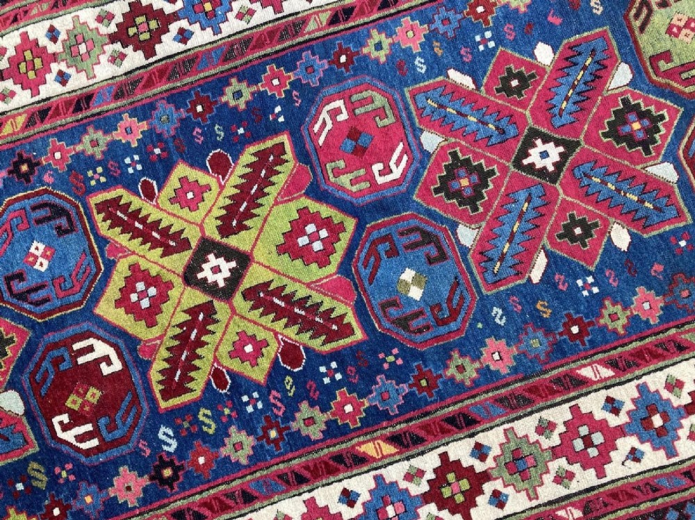 An elongated Caucasian Talish runner rug featuring geometric star motifs and octagons set against a deep indigo field with patterned borders. View X