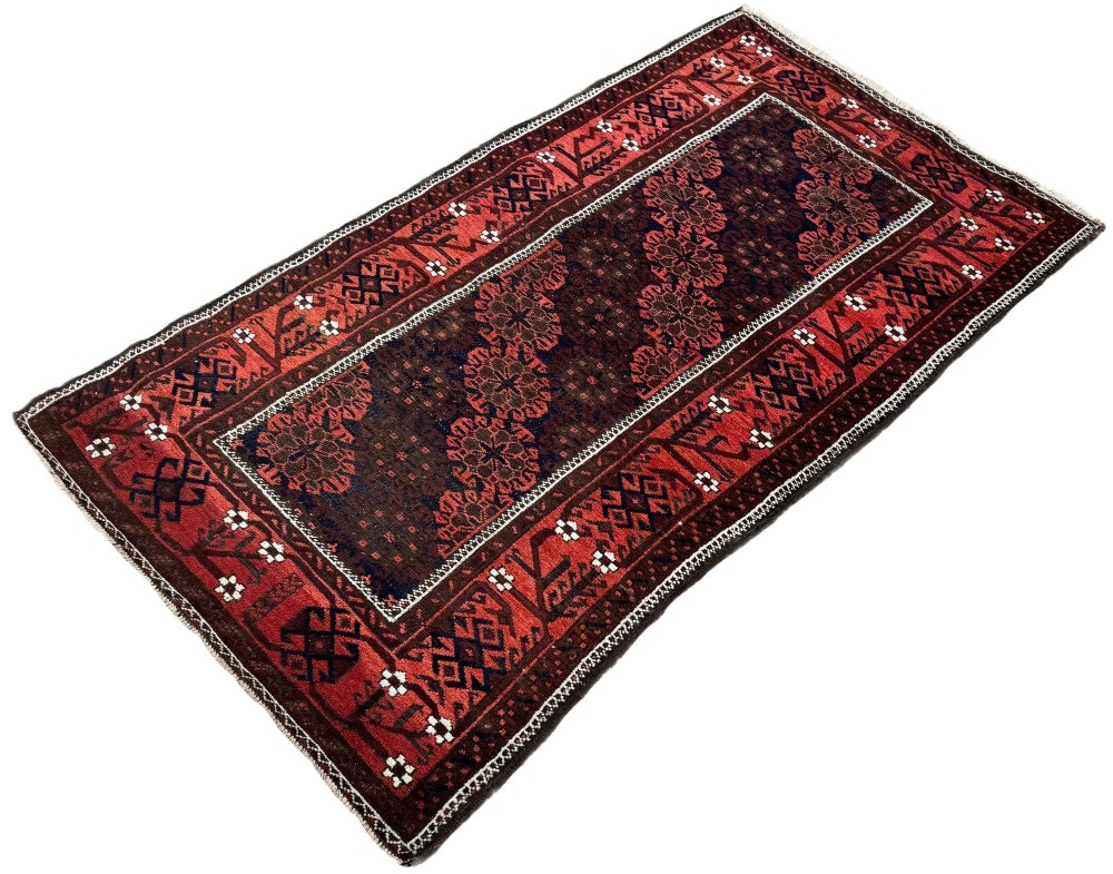 An antique hand-knotted Belouch wool rug featuring geometric star motifs, a dark brown central field, and a deep red patterned border. View III