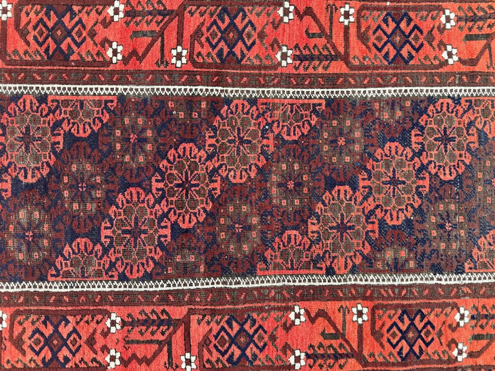 An antique hand-knotted Belouch wool rug featuring geometric star motifs, a dark brown central field, and a deep red patterned border. View XIII