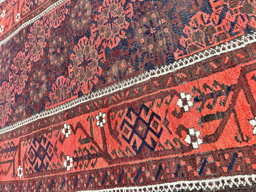 An antique hand-knotted Belouch wool rug featuring geometric star motifs, a dark brown central field, and a deep red patterned border. View XIV
