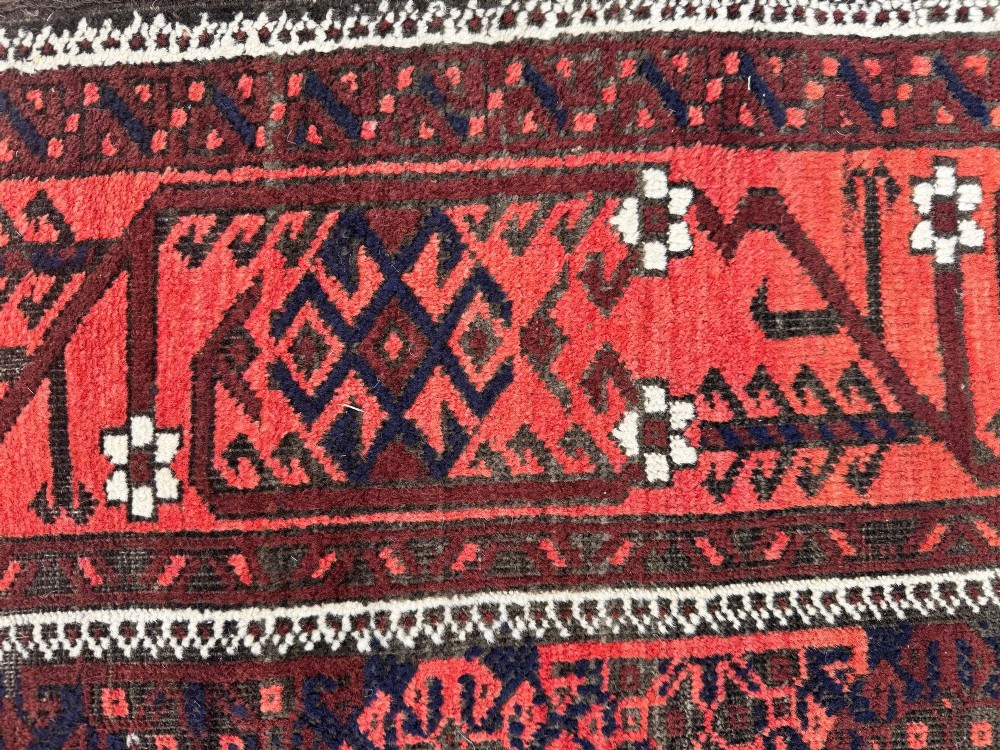 An antique hand-knotted Belouch wool rug featuring geometric star motifs, a dark brown central field, and a deep red patterned border. View XV