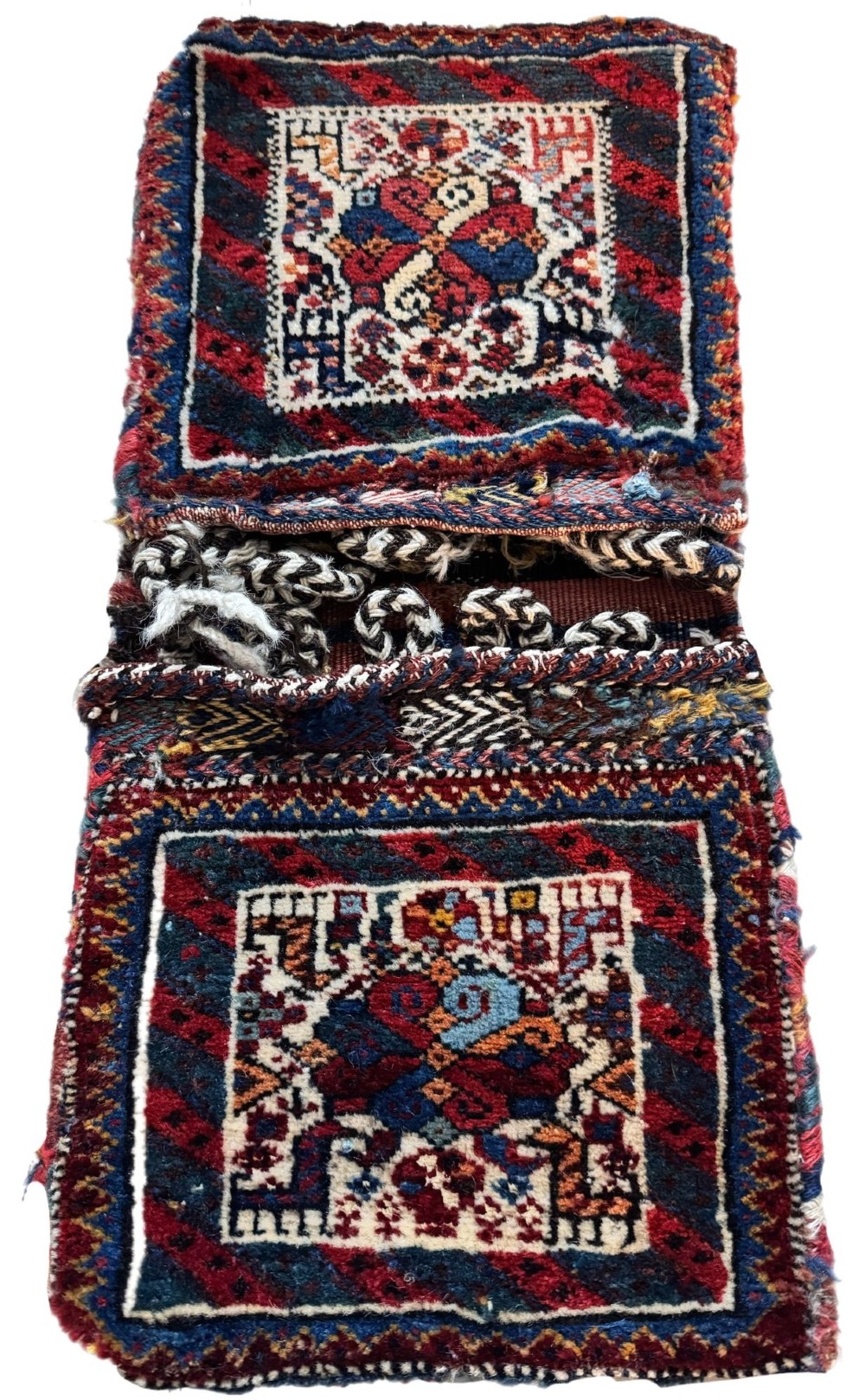 An antique handwoven Qashqai wool Khorjin double saddlebag featuring geometric medallions in red, navy, and cream with braided closure loops. View II
