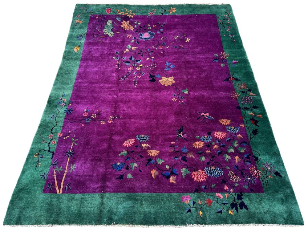 A large hand-knotted wool carpet featuring a vibrant magenta central field framed by a rich jade green border with asymmetrical floral and bamboo motifs. View II