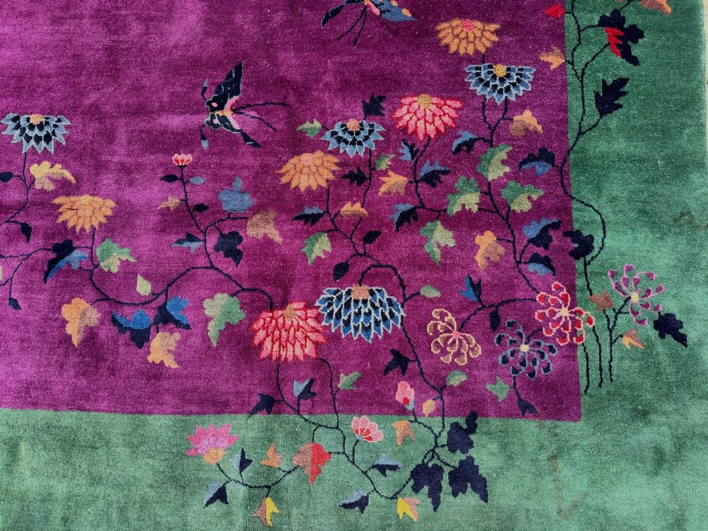 A large hand-knotted wool carpet featuring a vibrant magenta central field framed by a rich jade green border with asymmetrical floral and bamboo motifs. View VIII