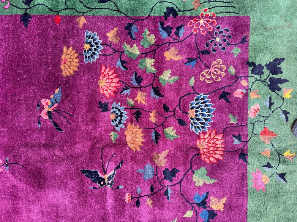 A large hand-knotted wool carpet featuring a vibrant magenta central field framed by a rich jade green border with asymmetrical floral and bamboo motifs. View XIII