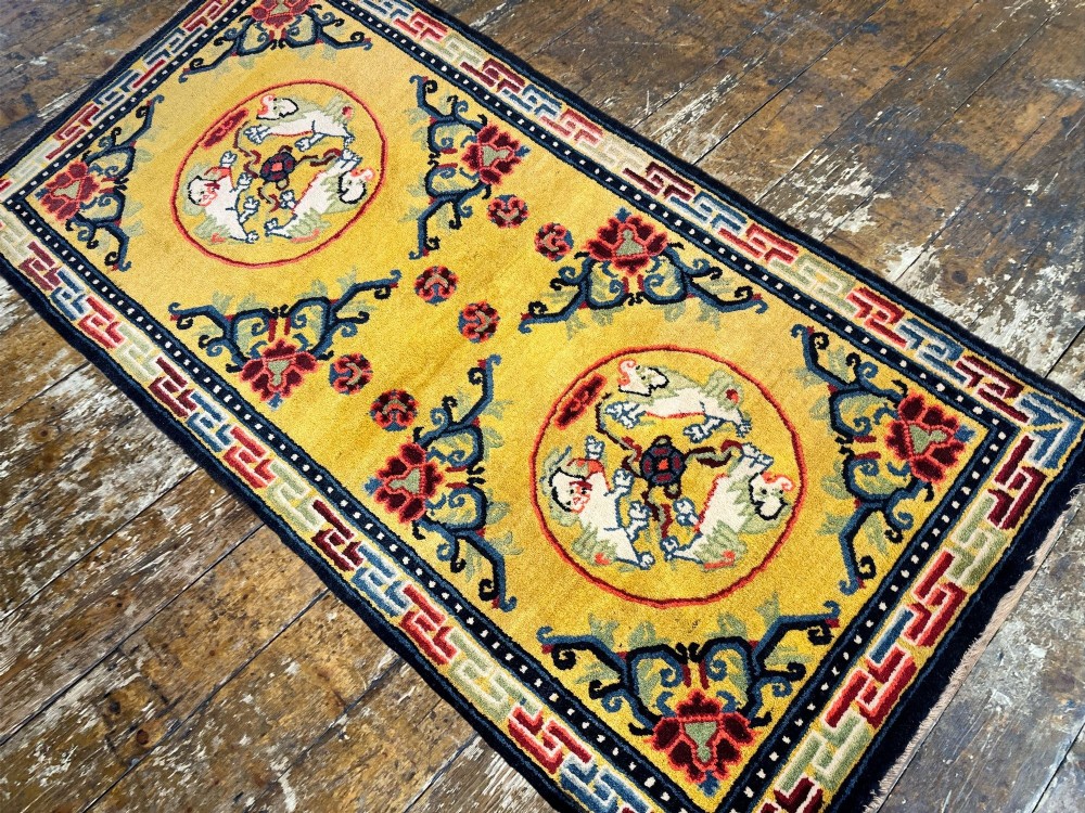 An antique hand-knotted Chinese Ningxia rectangular wool rug featuring a bright yellow field with two circular animal medallions, floral corner accents, and a blue geometric fretwork border. View VI