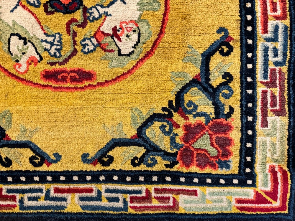 An antique hand-knotted Chinese Ningxia rectangular wool rug featuring a bright yellow field with two circular animal medallions, floral corner accents, and a blue geometric fretwork border. View VII