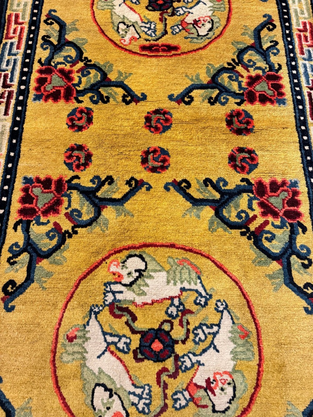 An antique hand-knotted Chinese Ningxia rectangular wool rug featuring a bright yellow field with two circular animal medallions, floral corner accents, and a blue geometric fretwork border. View VIII