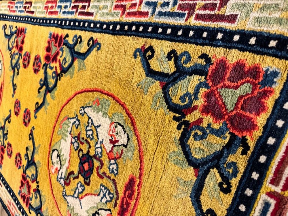 An antique hand-knotted Chinese Ningxia rectangular wool rug featuring a bright yellow field with two circular animal medallions, floral corner accents, and a blue geometric fretwork border. View IX