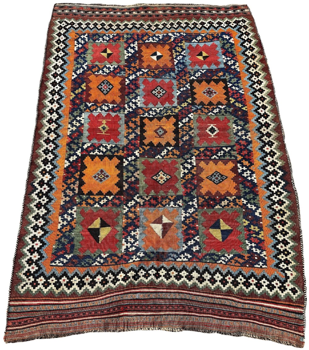 An antique handwoven Qashqai wool kilim rug featuring geometric stepped diamond motifs in terracotta red, ochre orange, indigo blue, and ivory. View II