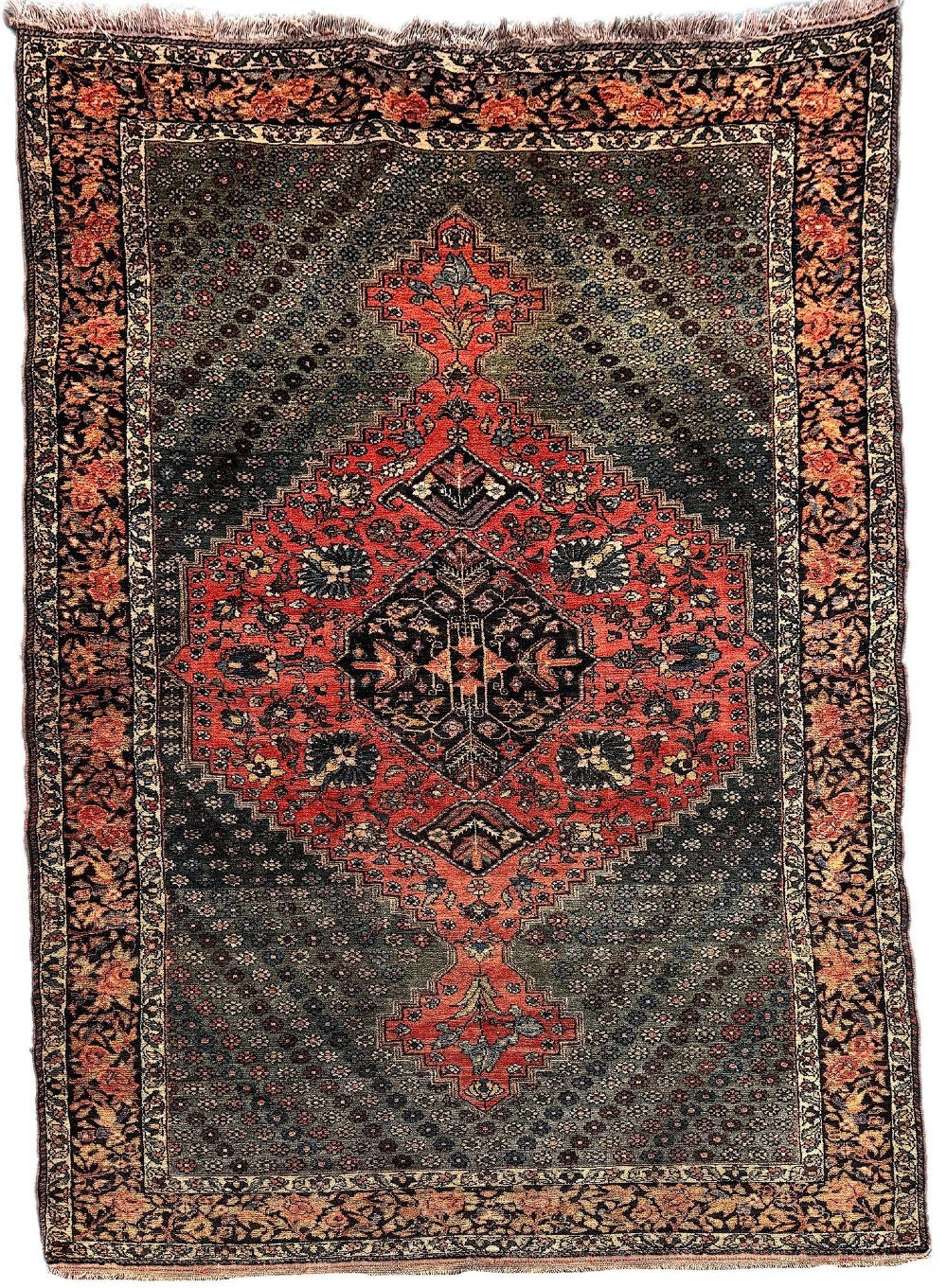 An antique hand-knotted Bakhtiar wool rug featuring a central terracotta stepped medallion on a dark indigo field filled with intricate floral motifs.