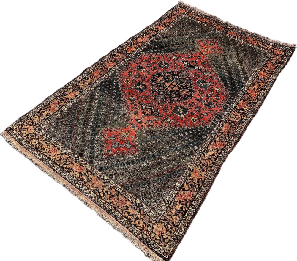 An antique hand-knotted Bakhtiar wool rug featuring a central terracotta stepped medallion on a dark indigo field filled with intricate floral motifs. View III