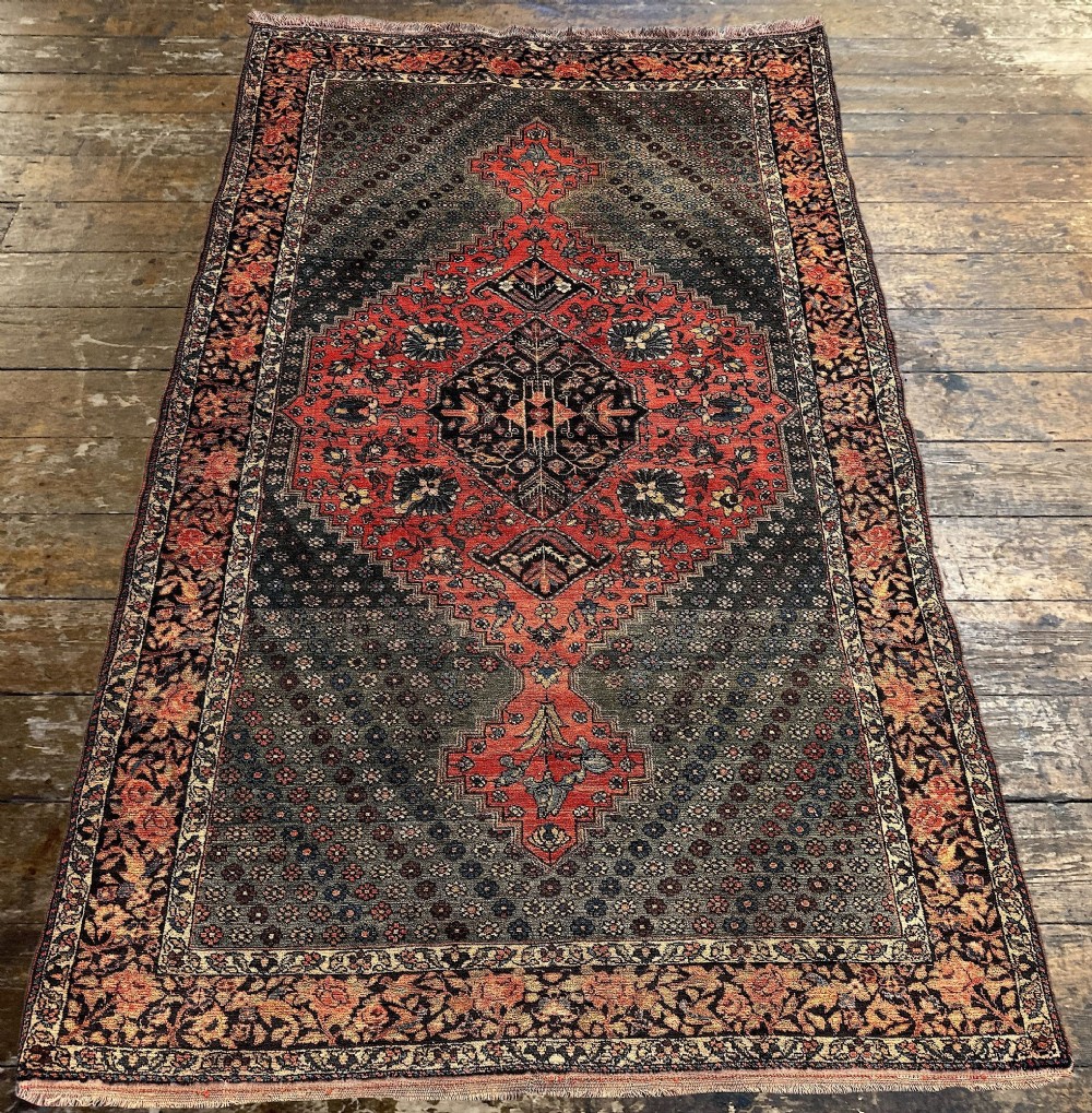 An antique hand-knotted Bakhtiar wool rug featuring a central terracotta stepped medallion on a dark indigo field filled with intricate floral motifs. View IV