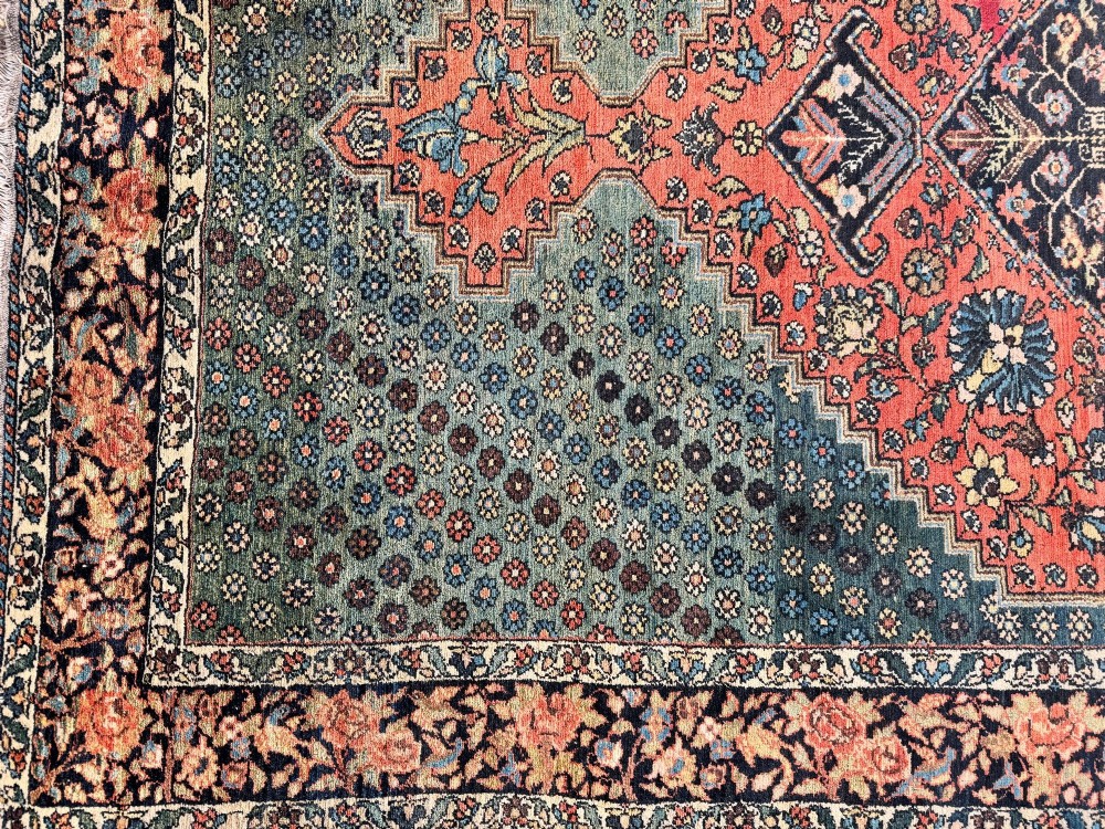 An antique hand-knotted Bakhtiar wool rug featuring a central terracotta stepped medallion on a dark indigo field filled with intricate floral motifs. View XII