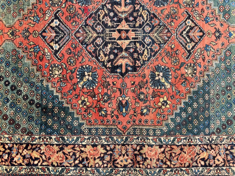An antique hand-knotted Bakhtiar wool rug featuring a central terracotta stepped medallion on a dark indigo field filled with intricate floral motifs. View XIII