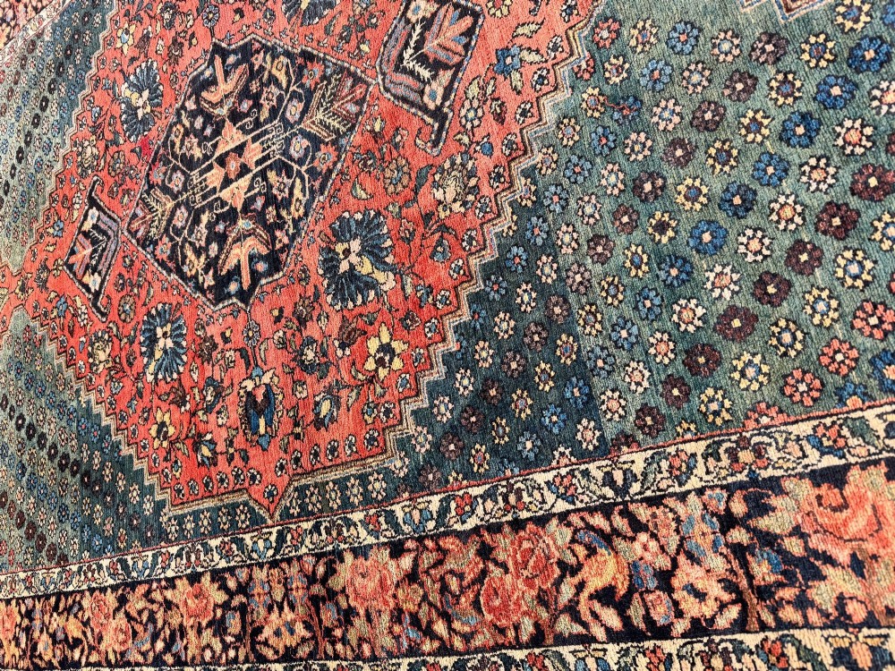 An antique hand-knotted Bakhtiar wool rug featuring a central terracotta stepped medallion on a dark indigo field filled with intricate floral motifs. View XIV