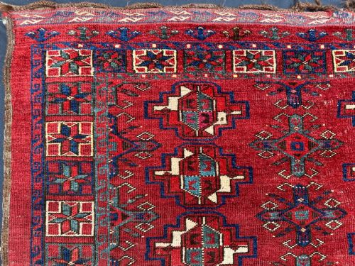 fig 1. A rectangular handwoven antique Turkmen Chuval wool textile featuring geometric red and navy motifs with decorative borders.