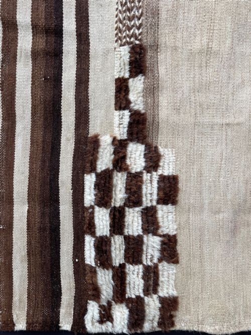 fig 1. A square antique woven Persian Tacheh textile with brown and cream vertical stripes alongside a distinctive chequered pile section.