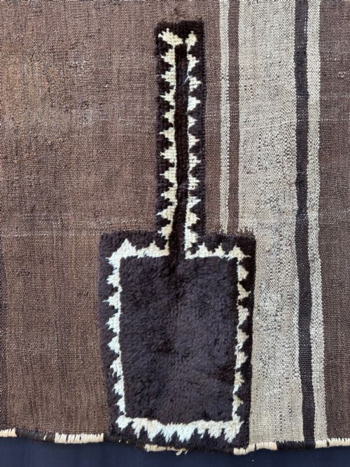 fig 1. A square antique handwoven Persian Tacheh featuring vertical brown and beige stripes with a dark central raised pile motif.