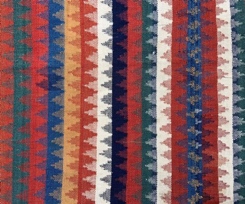 fig 1. An antique Persian Qashqai flatwoven wool textile featuring vertical striped bands with serrated geometric motifs in terracotta red, dark blue, yellow, and cream, complete with knotted fringe ends.