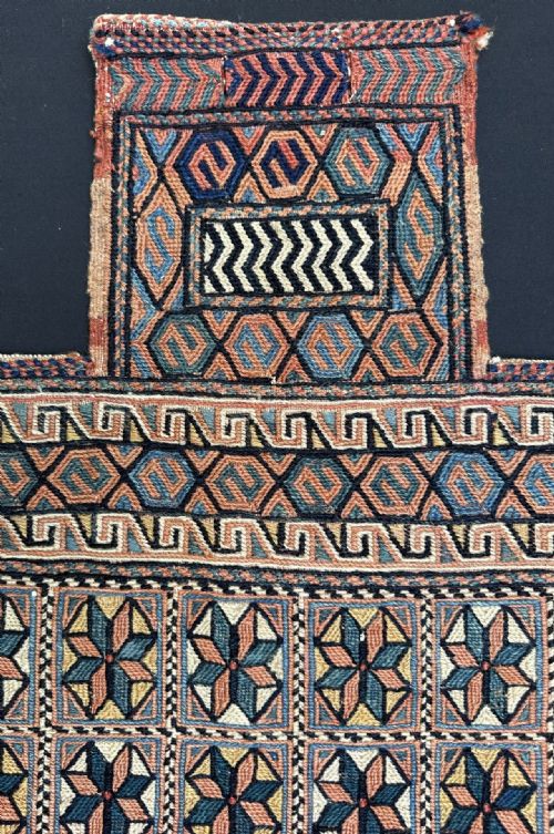 fig 1. An antique Persian Afshar woven wool salt bag featuring a bottle-neck top and geometric star motifs in terracotta, blue, and ochre.