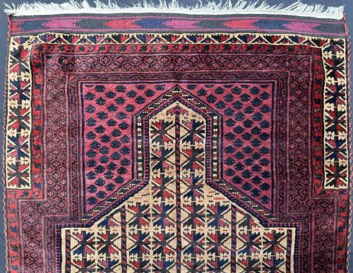 fig 1. Hand-knotted wool tribal prayer rug featuring a central arch niche design in tan, deep red, and dark navy tones.