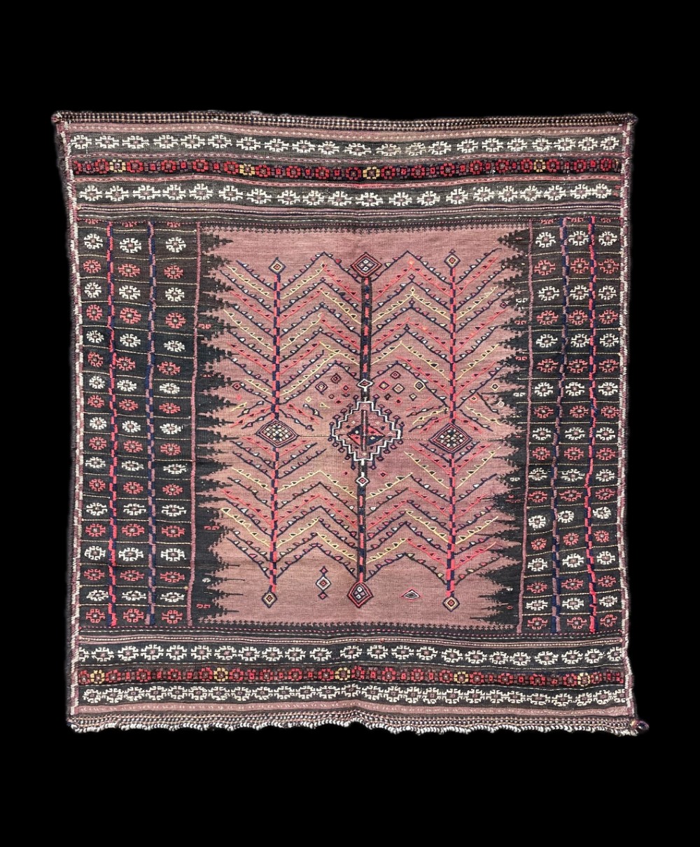 A square antique handwoven Ru Korsi textile featuring a dusty purple central field with chevron tree motifs bordered by dark geometric band patterns.