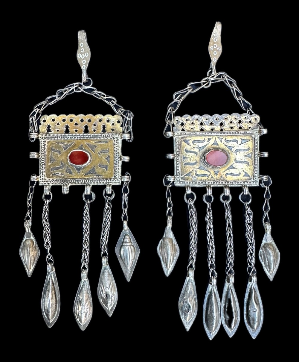 A pair of Teke Turkmen silver drop earrings featuring rectangular gilded plates set with oval carnelian cabochons and suspended dangles.
