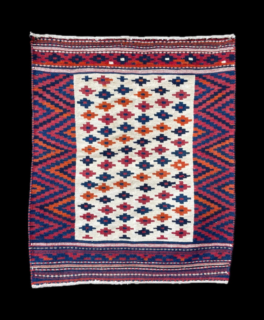 A rectangular handwoven Persian Bakhtiari bread sofreh flatweave textile featuring a cream centre field with geometric cross motifs framed by red and navy zigzag borders.