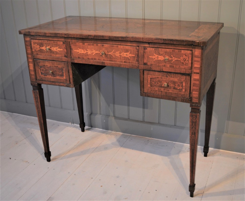 An Italian Neoclassical writing desk crafted from walnut with foliate marquetry inlay across the drawers, tabletop, and tapered legs.