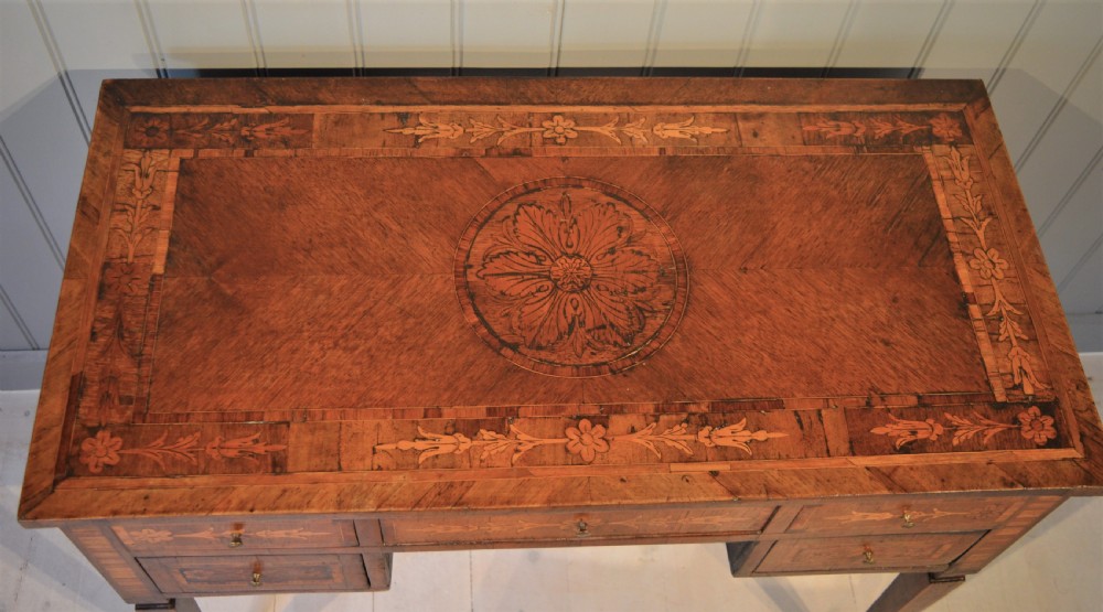 An Italian Neoclassical writing desk crafted from walnut with foliate marquetry inlay across the drawers, tabletop, and tapered legs. View II