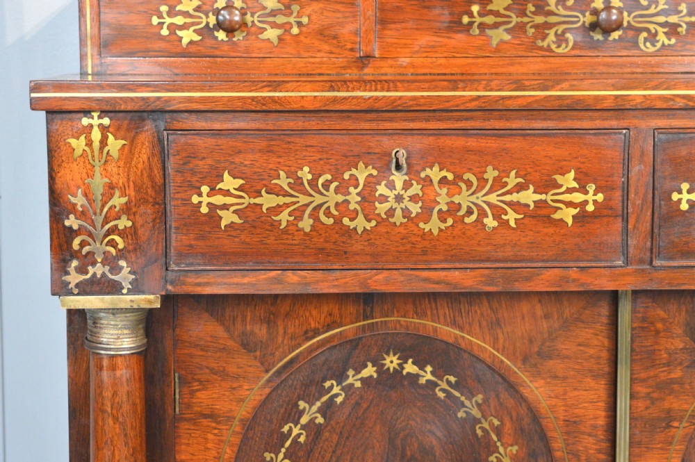 A dark rosewood Regency chiffonier side cabinet featuring brass foliate marquetry, a two-door arched cupboard, drawer storage, and a top shelf with a brass gallery. View V