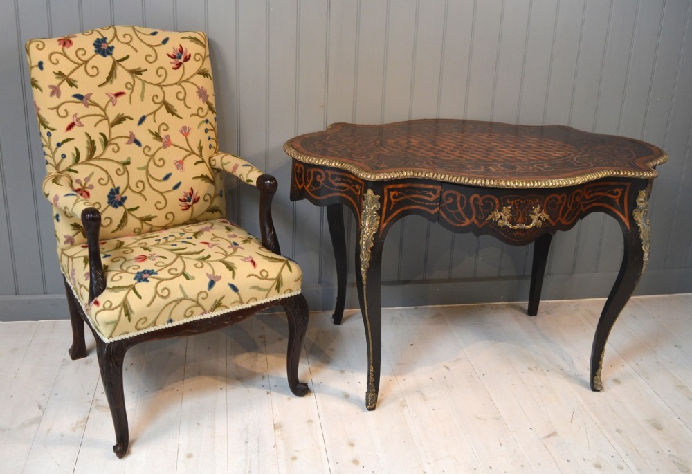 A French Louis XV style centre table featuring geometric cubed parquetry, scroll marquetry, a serpentine top, and decorative brass mounts. View VIII