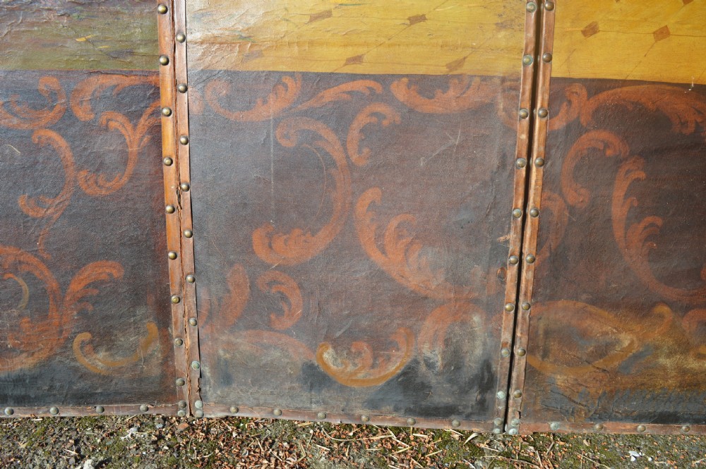 A four-panel antique folding room screen featuring painted classical architectural columns, figures in period dress, and scrolling acanthus base motifs with studded brass edging. View VII