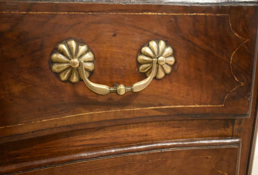 A French provincial walnut commode with three long drawers featuring brass rosette drop handles, keyhole escutcheons, and curved legs. View VIII