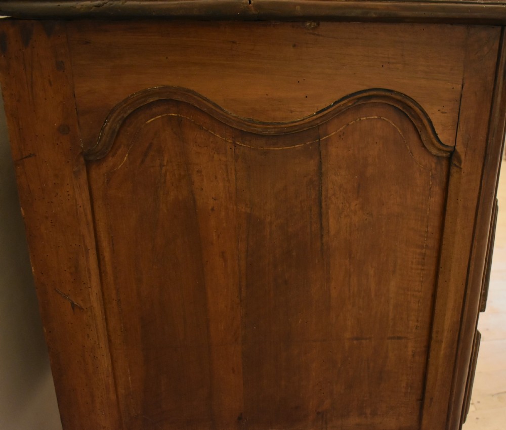 A French provincial walnut commode with three long drawers featuring brass rosette drop handles, keyhole escutcheons, and curved legs. View XIII