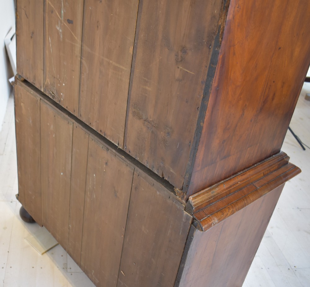 A Queen Anne walnut fall-front secretaire featuring a fitted interior with small drawers, green baize writing surface, brass drop handles, and turned bun feet. View VII
