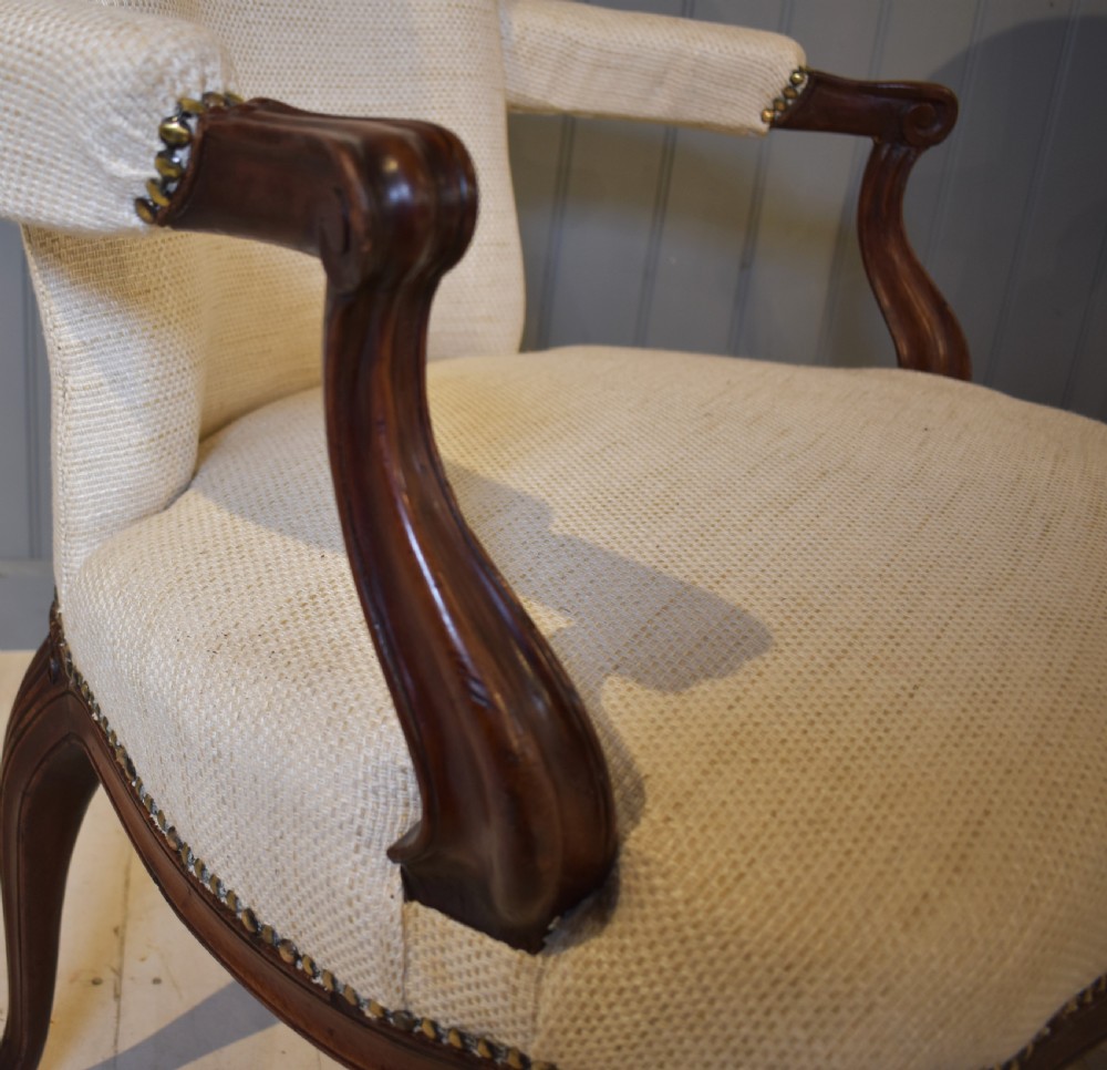 A pair of French Hepplewhite style armchairs upholstered in textured cream linen with carved dark mahogany frames and brass stud detailing. View VI