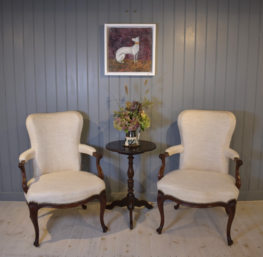A pair of French Hepplewhite style armchairs upholstered in textured cream linen with carved dark mahogany frames and brass stud detailing. View VIII