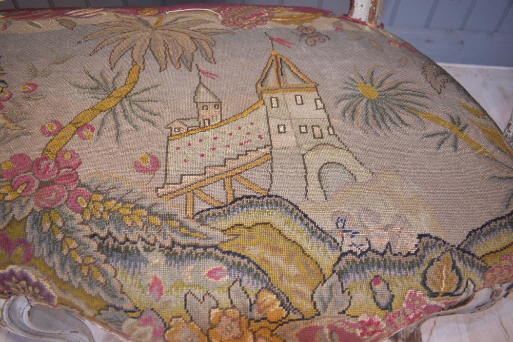 A French Louis XV style painted wooden settee with serpentine rails, cabriole legs, and woven tapestry upholstery featuring birds and palm trees. View IX