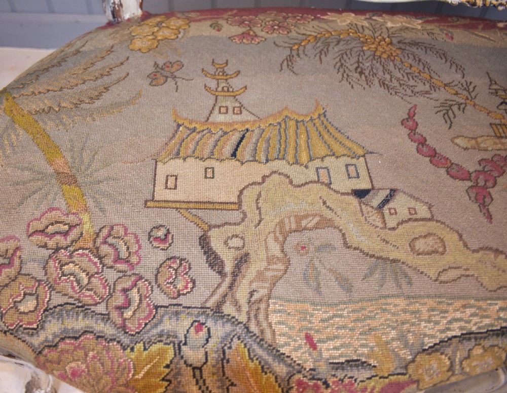 A French Louis XV style painted wooden settee with serpentine rails, cabriole legs, and woven tapestry upholstery featuring birds and palm trees. View X