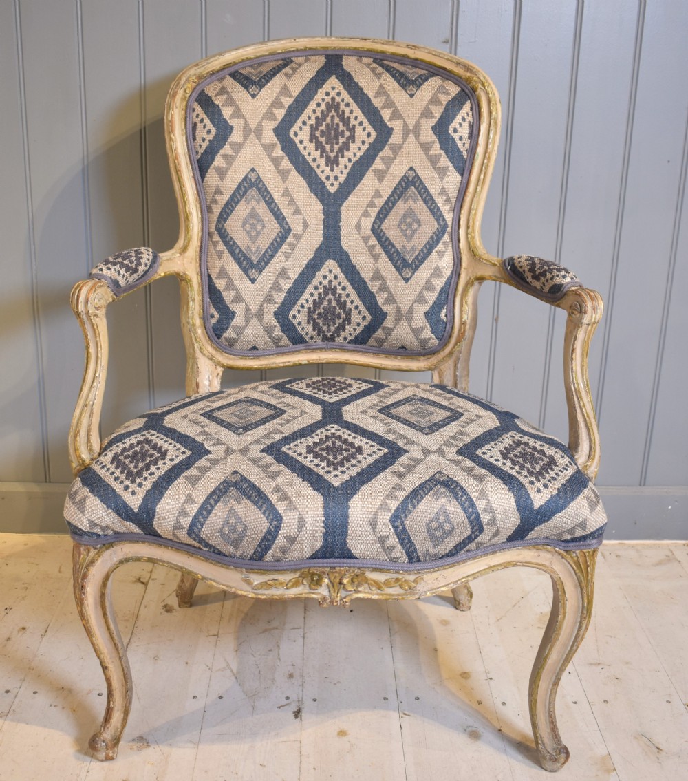 A French painted fauteuil armchair featuring cabriole legs, a carved cream frame with distressed finish, and blue geometric upholstery. View II