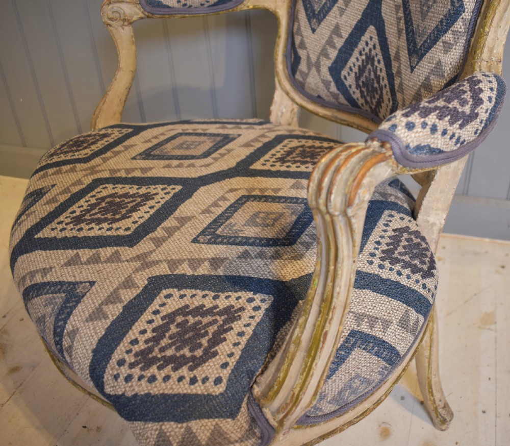 A French painted fauteuil armchair featuring cabriole legs, a carved cream frame with distressed finish, and blue geometric upholstery. View III