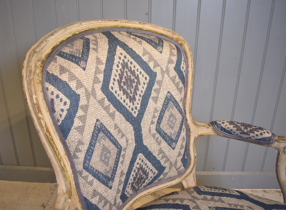 A French painted fauteuil armchair featuring cabriole legs, a carved cream frame with distressed finish, and blue geometric upholstery. View IV