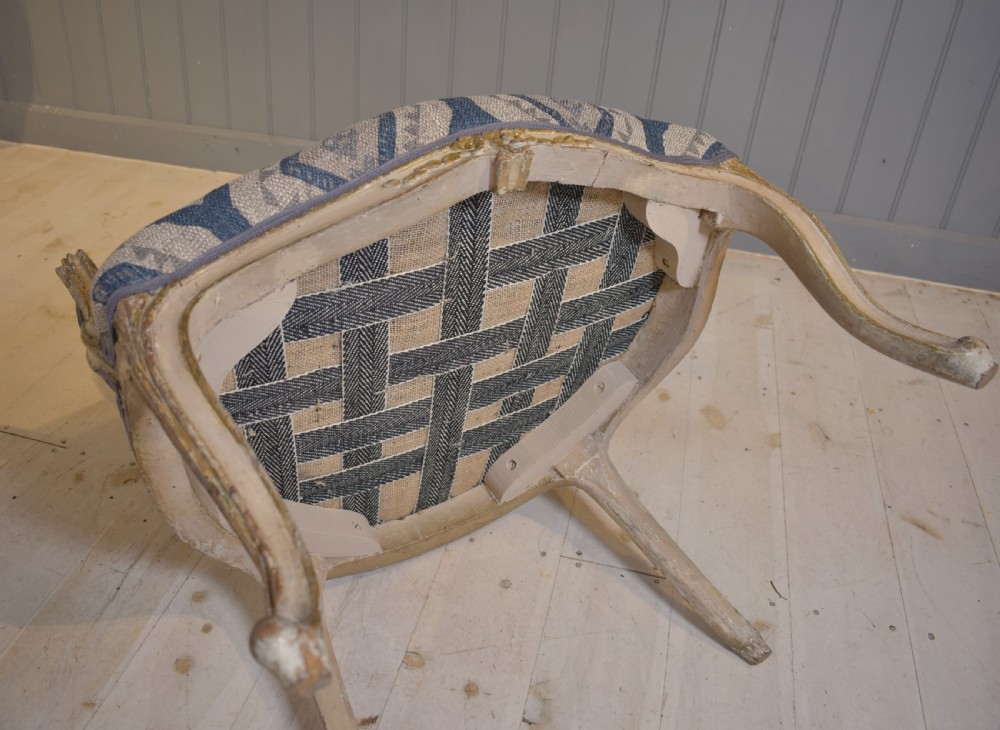 A French painted fauteuil armchair featuring cabriole legs, a carved cream frame with distressed finish, and blue geometric upholstery. View VI