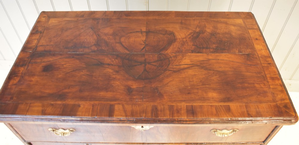 An early 18th-century George I walnut kneehole desk featuring brass handles, a central recessed cupboard, and bracket feet. View IV