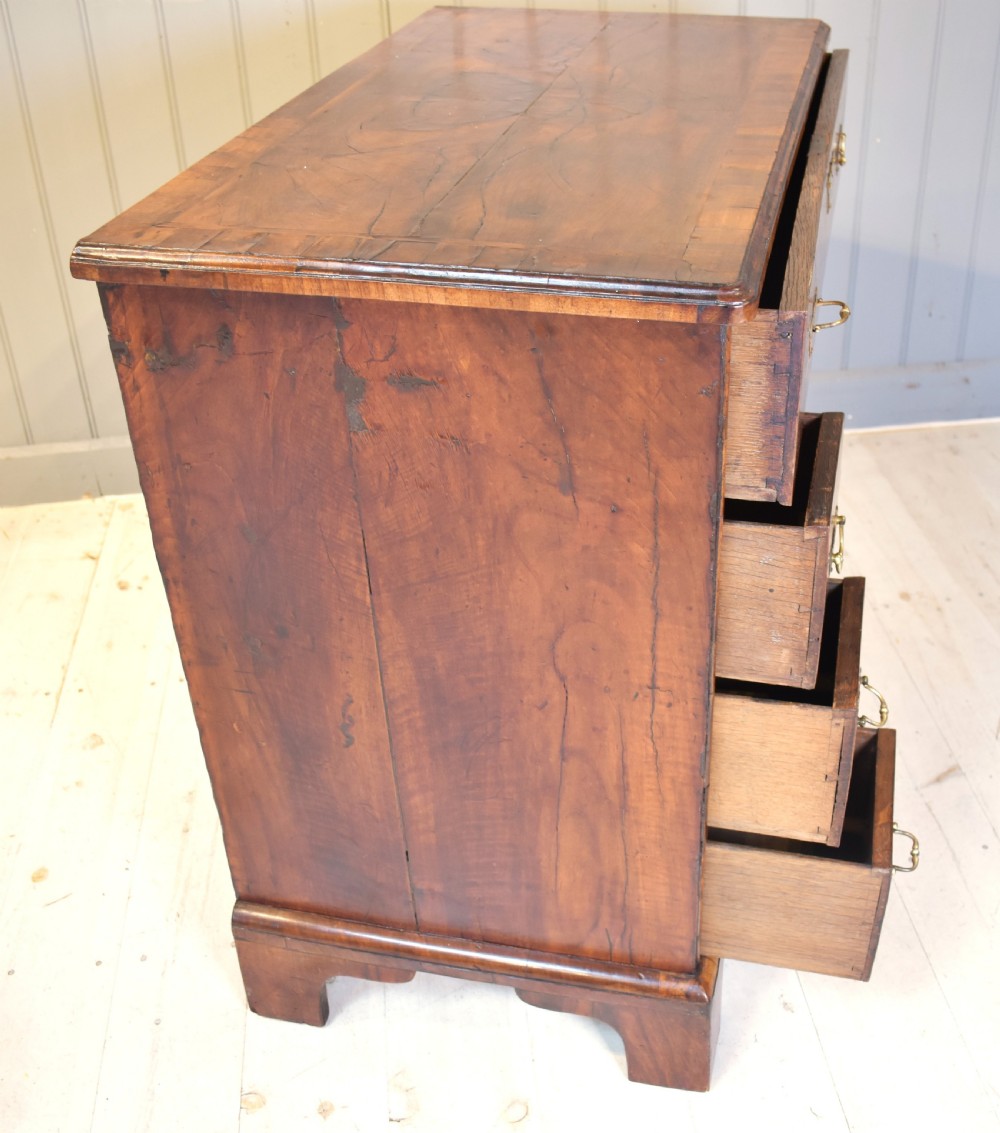 An early 18th-century George I walnut kneehole desk featuring brass handles, a central recessed cupboard, and bracket feet. View IX